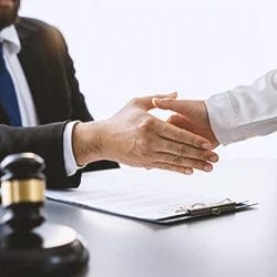 A lawyer shaking hands with a client in an office