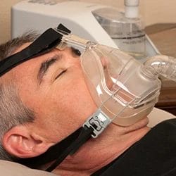A man sleeping with his CPAP Mask on