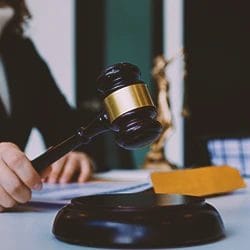 A lawyer holding a gavel on a table