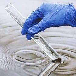 A chemist getting water into a test tube