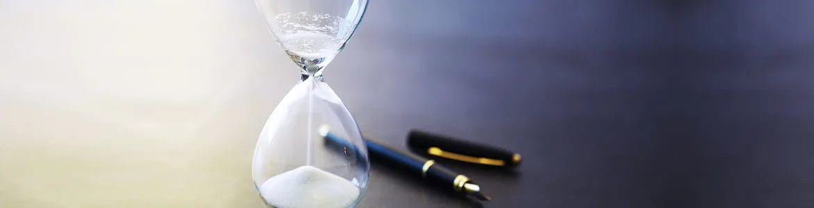 white hourglass and an opened pen